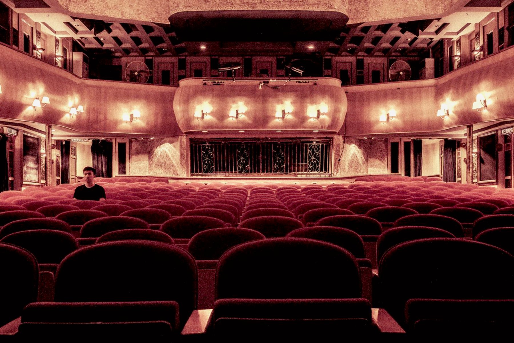 Theatre auditorium with red seats looking toward the stage